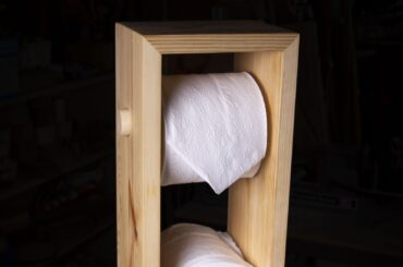 A toilet paper tower made out of scrap pine wood.